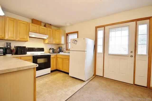 a kitchen with sink cabinets and white appliances