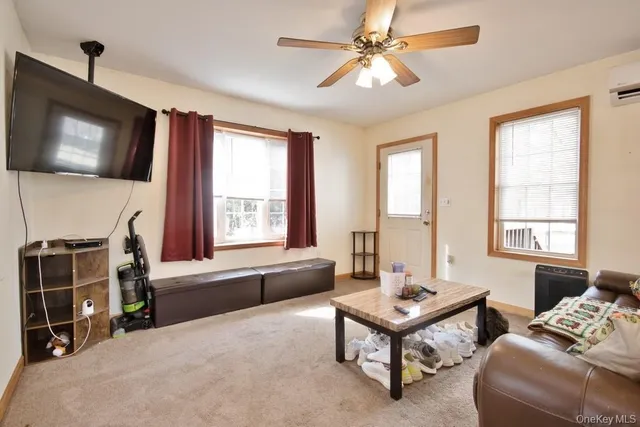 a living room with furniture a flat screen tv and a window