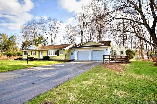 a view of a house with a big yard and large trees