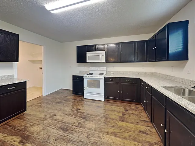 a kitchen with stainless steel appliances granite countertop a stove a sink and a microwave