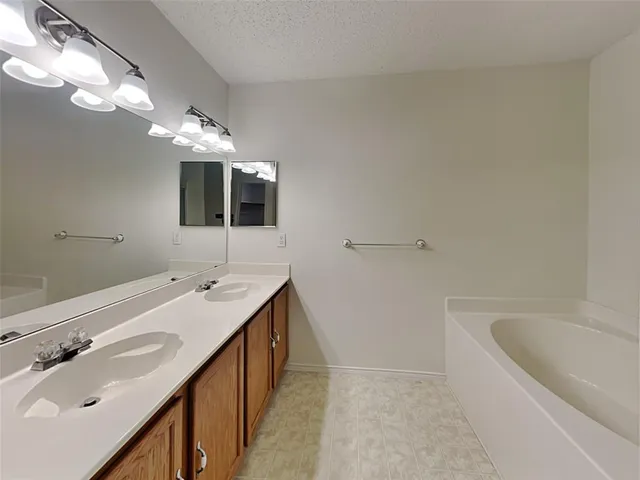 a bathroom with a tub sink and mirror