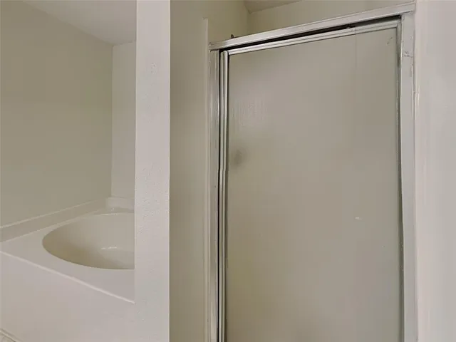 a bathroom with a shower and a bath tub