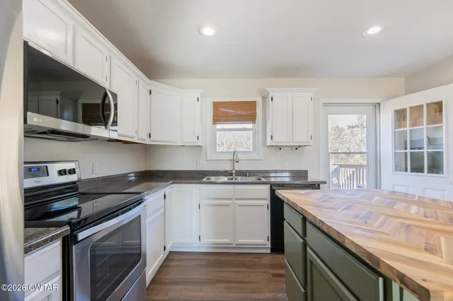 a kitchen with stainless steel appliances granite countertop a sink stove and microwave