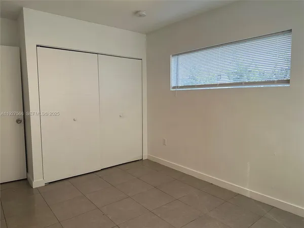 a view of an empty room with a kitchen