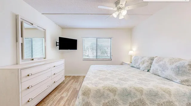 a bedroom with a large bed and a flat tv screen on dresser