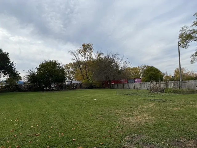 a view of a field of grass and trees