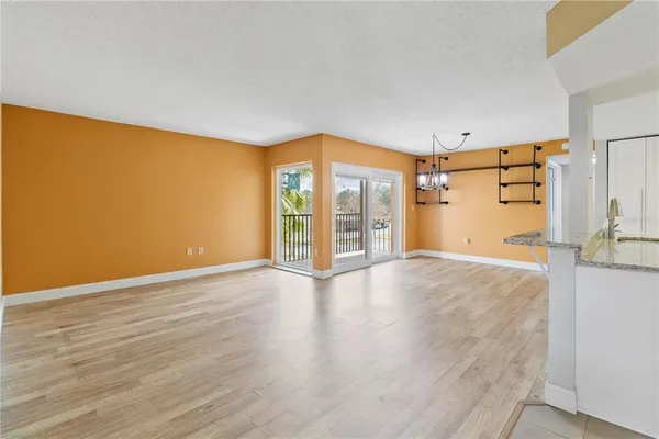 a view of empty room with wooden floor and entryway
