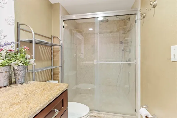 a bathroom with a granite countertop sink toilet and shower