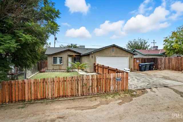 a view of a house with wooden fence next to a road