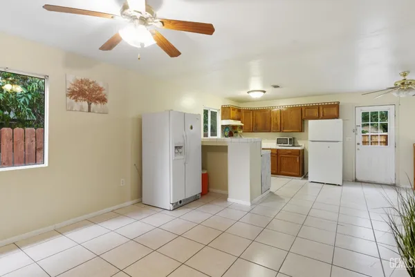 a view of a kitchen with fridge and wooden floor