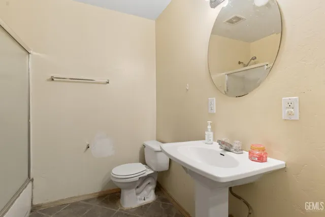 a bathroom with a sink toilet and mirror