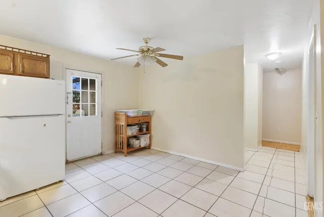 a view of room with cabinet and a ceiling fan