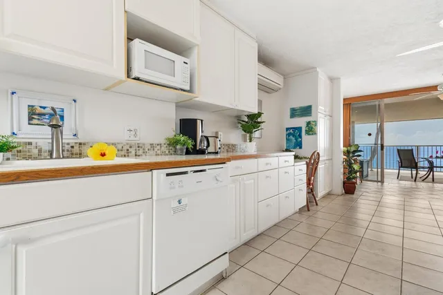 a large white kitchen with kitchen island granite countertop a large counter top and sink