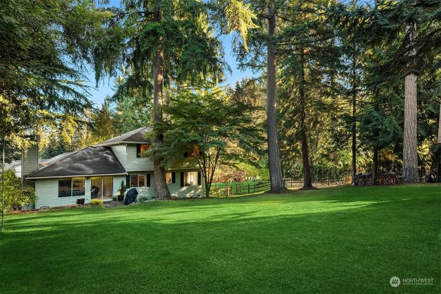 a view of an house with backyard and a tree