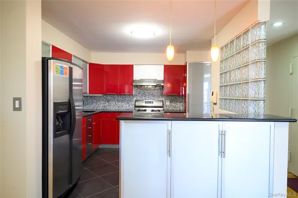 a kitchen with stainless steel appliances granite countertop a refrigerator and a sink