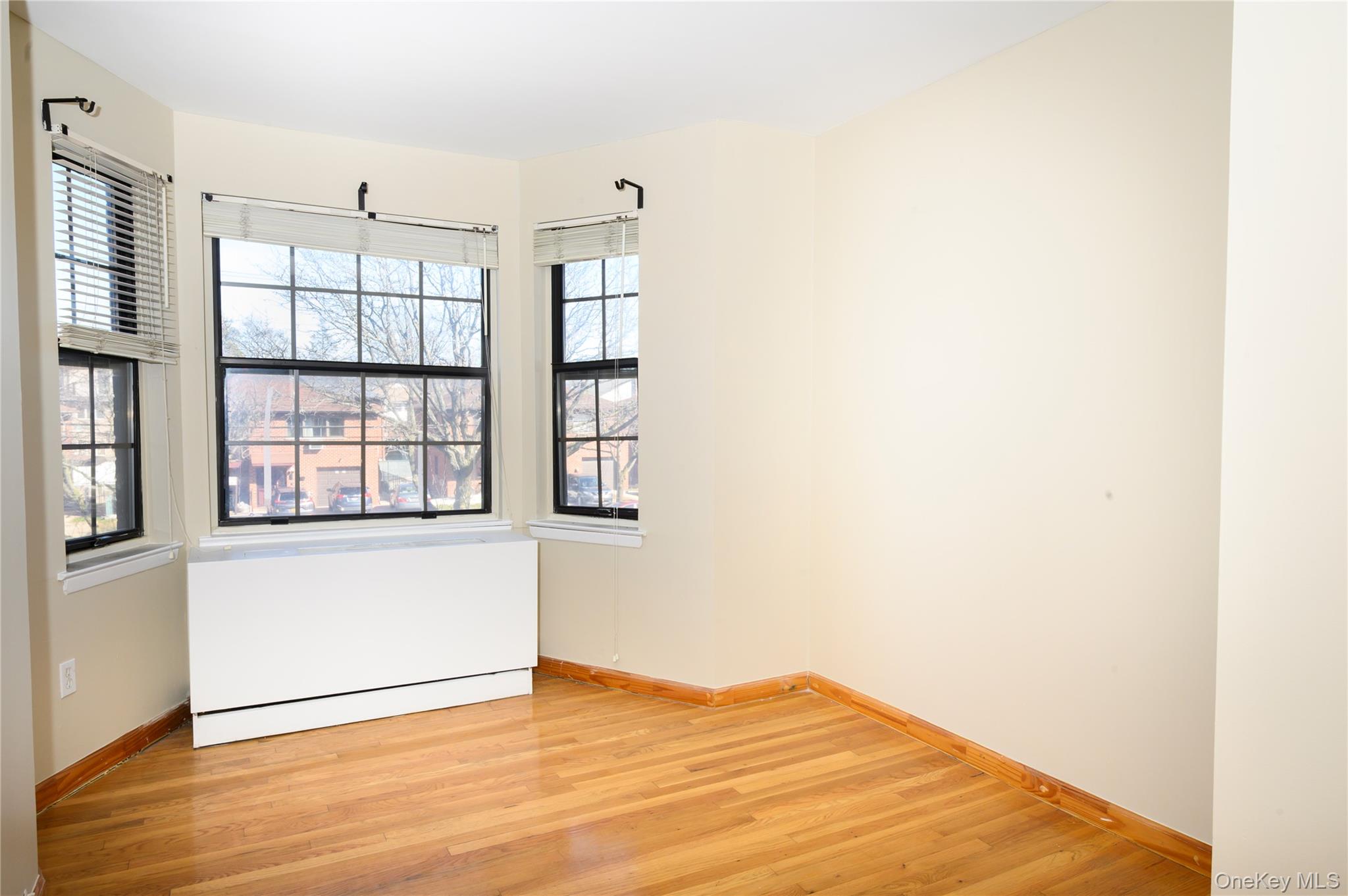 7124 164th Street, Unit 2 Queens, NY 11365 - Photo 15 of 22 an empty room with wooden floor and windows