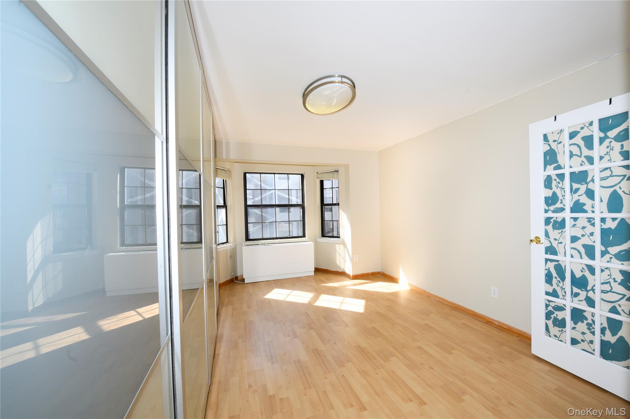7124 164th Street, Unit 2 Queens, NY 11365 - Photo 17 of 22 a view of an empty room with glass door and a window