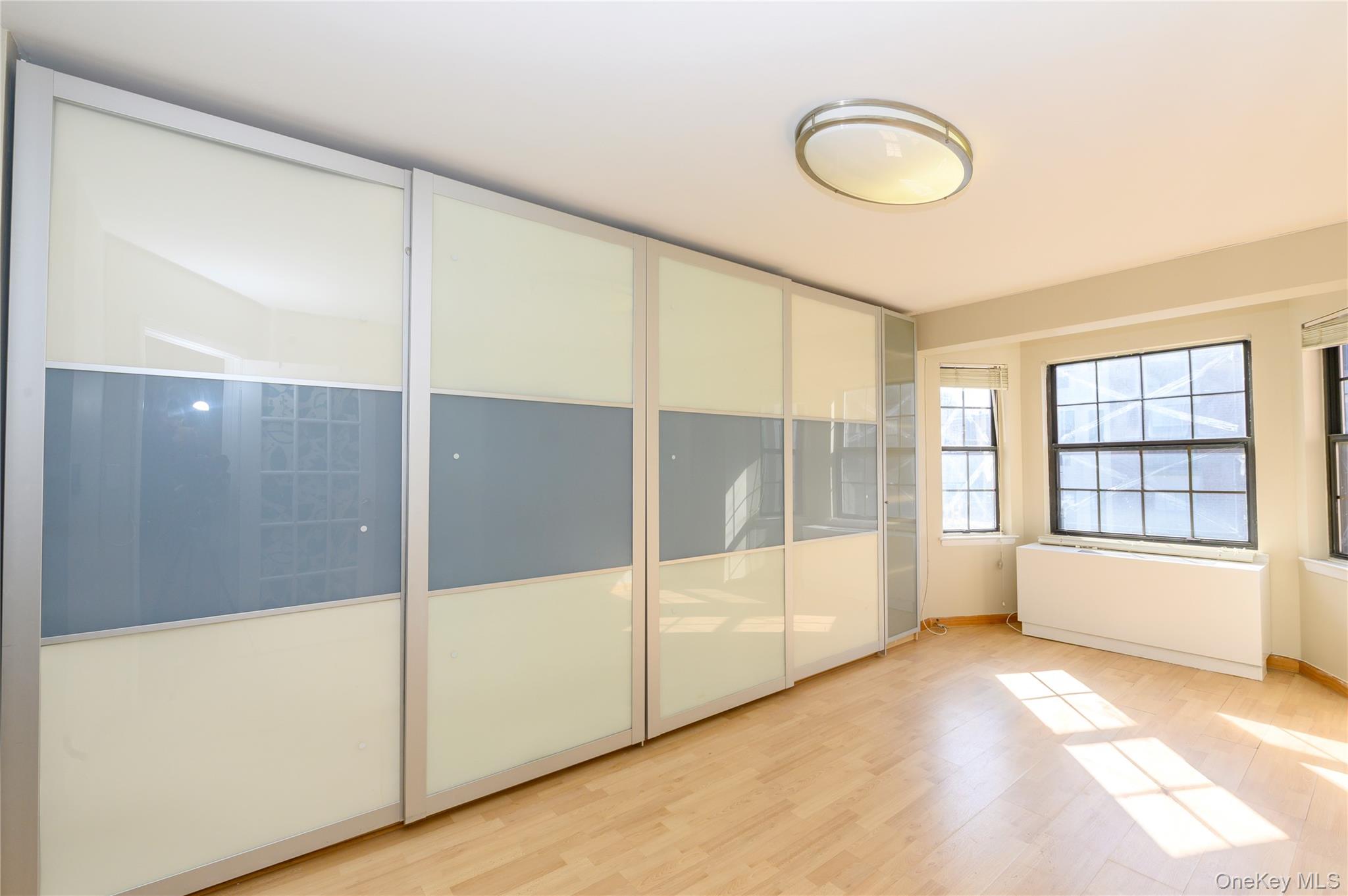 7124 164th Street, Unit 2 Queens, NY 11365 - Photo 18 of 22 a view of an empty room with wooden floor and a window