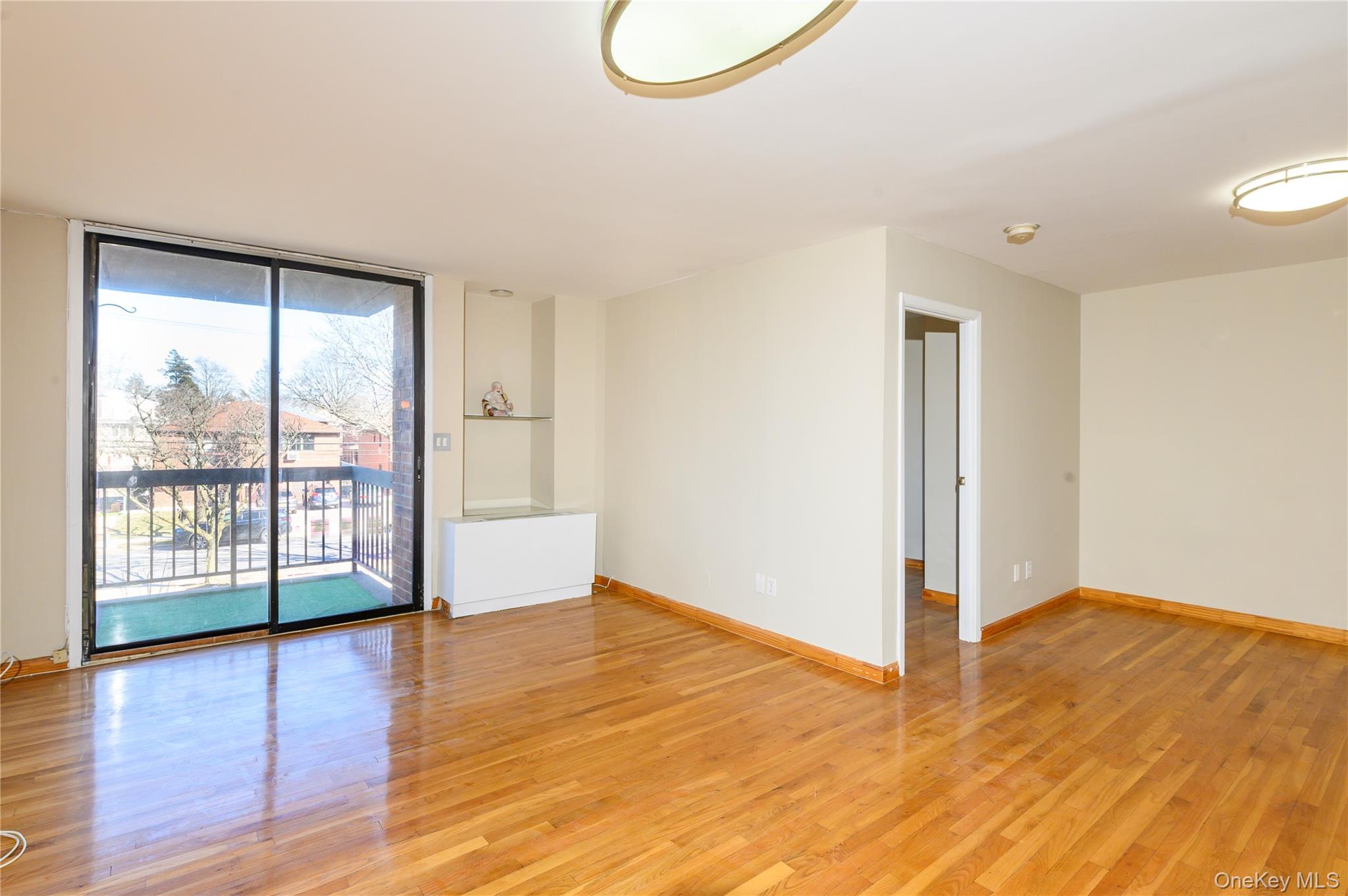 7124 164th Street, Unit 2 Queens, NY 11365 - Photo 5 of 22 a view of an empty room with wooden floor and a window
