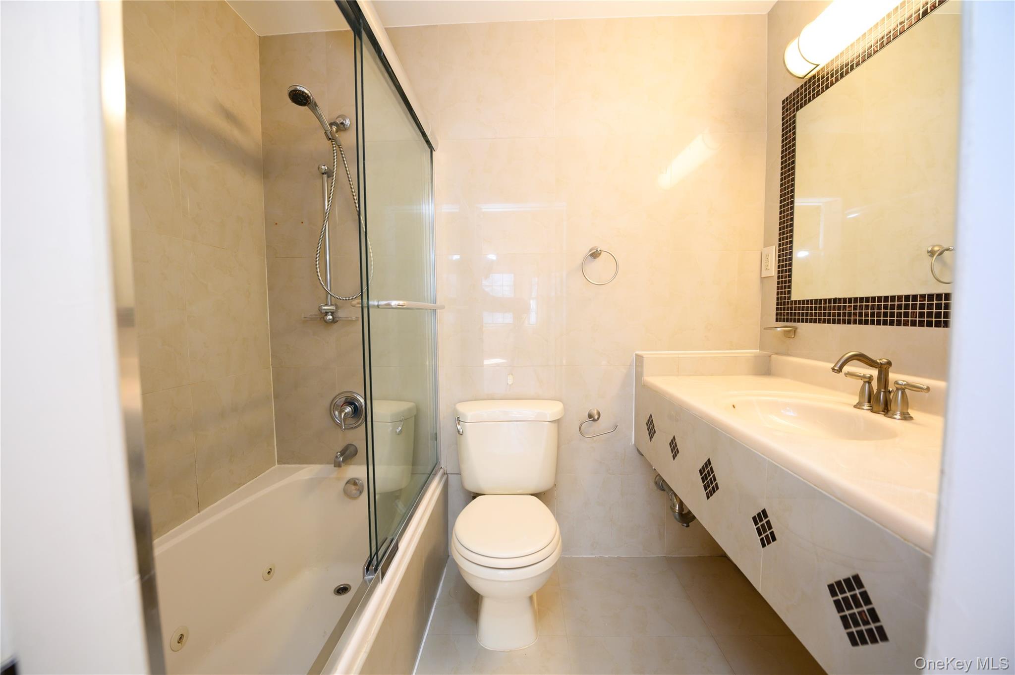 7124 164th Street, Unit 2 Queens, NY 11365 - Photo 7 of 22 a bathroom with a sink a toilet and shower