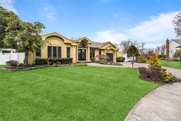 a front view of a house with a yard and trees