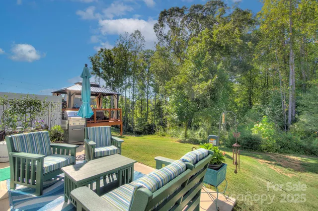 a backyard of a house with plants and large trees