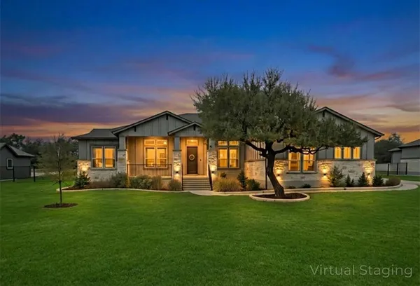 a front view of a house with a yard and trees