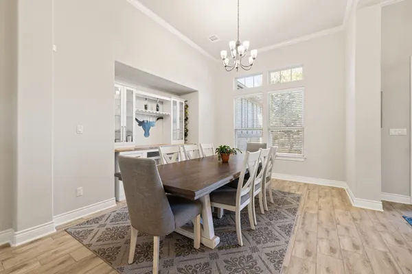 a kitchen with stainless steel appliances kitchen island granite countertop a dining table chairs refrigerator and sink