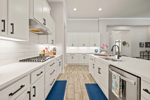 a large white bedroom with a large bed and a flat tv screen on dresser