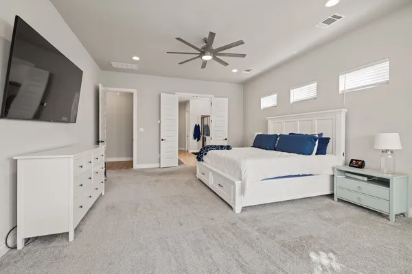 a bedroom with a bed a chair and a chandelier