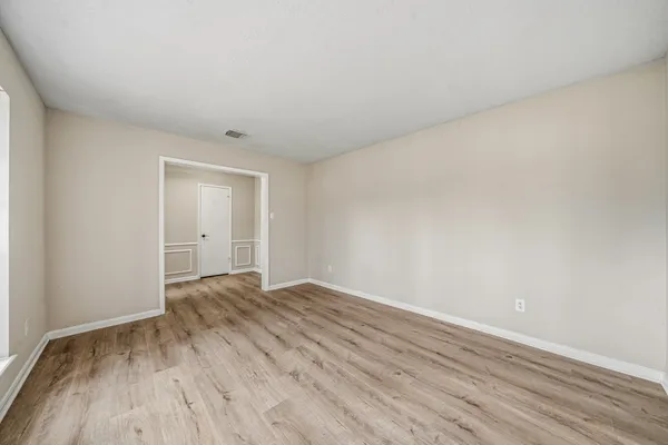 a view of an empty room and wooden floor