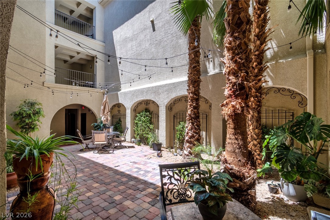 2555 Hampton Road, Unit 6308 Henderson, NV 89052 - Photo 27 of 30 Building #6 inviting courtyard beckons with string lights, lush plants, and charming patio seating.