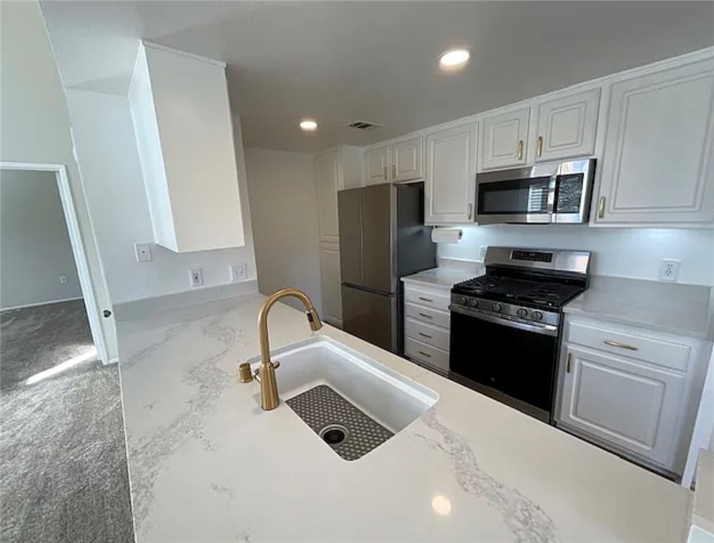 20000 Plum Canyon Road, Unit 225 Saugus, CA 91350 - Photo 4 of 12 a kitchen with granite countertop a refrigerator stove and sink