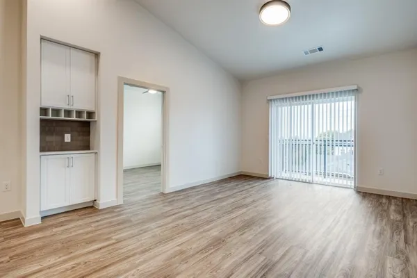 an empty room with wooden floor and cabinet