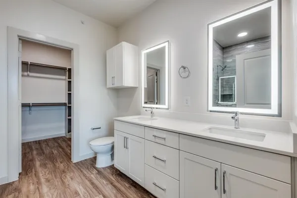 a bathroom with a double vanity sink a toilet and a mirror