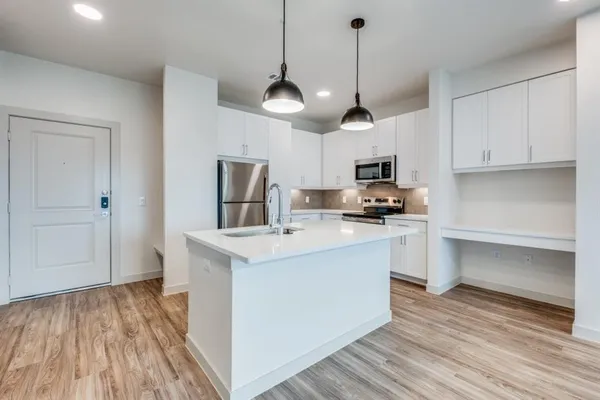 a kitchen with kitchen island a sink stainless steel appliances and cabinets