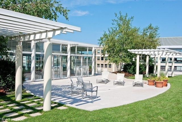 1640 Maple Avenue, Unit 1606 Evanston, IL 60201 - Photo 33 of 40 a view of a patio with table and chairs potted plants and floor to ceiling window