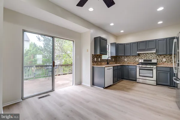 a kitchen with granite countertop a stove top oven and cabinets