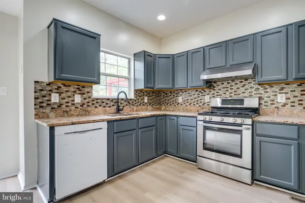 a kitchen with granite countertop cabinets stainless steel appliances and sink
