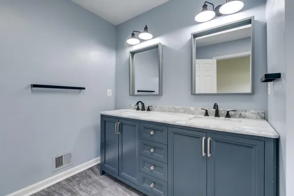 a bathroom with a granite countertop sink vanity and mirror