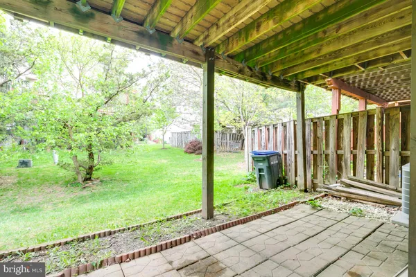 a porch with a table and chairs next to a yard