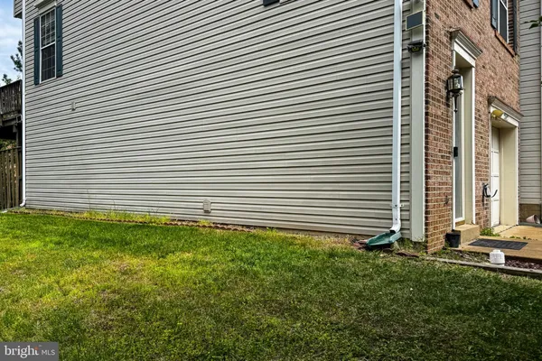 a view of a backyard with plants and brick walls