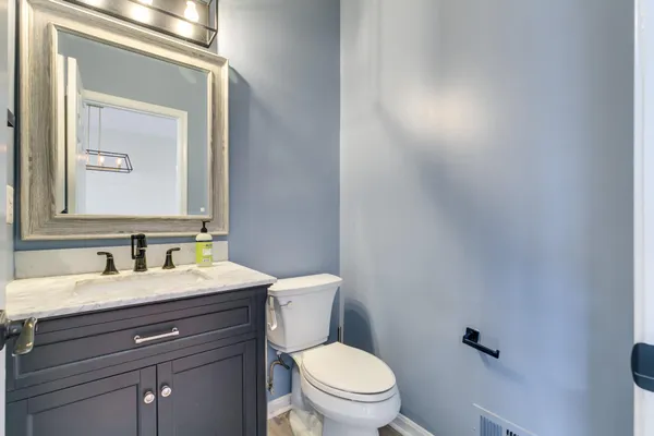 a bathroom with a toilet a sink and mirror