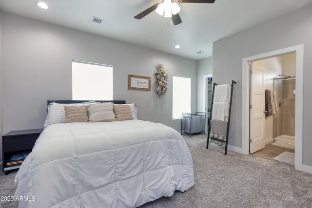 a spacious bedroom with a bed and a chandelier