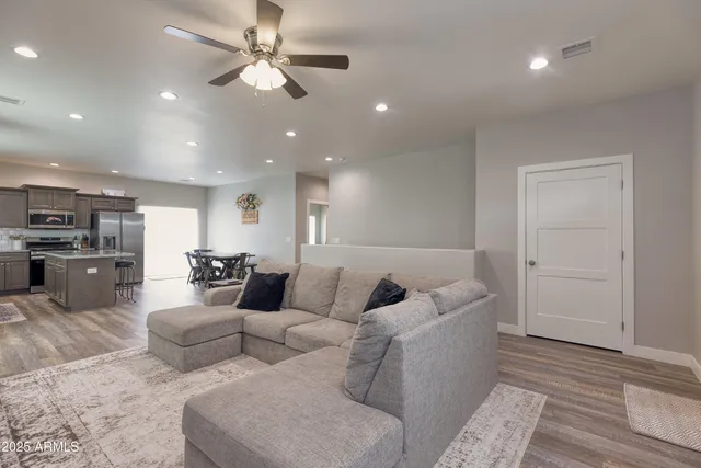 a living room with furniture and a ceiling fan