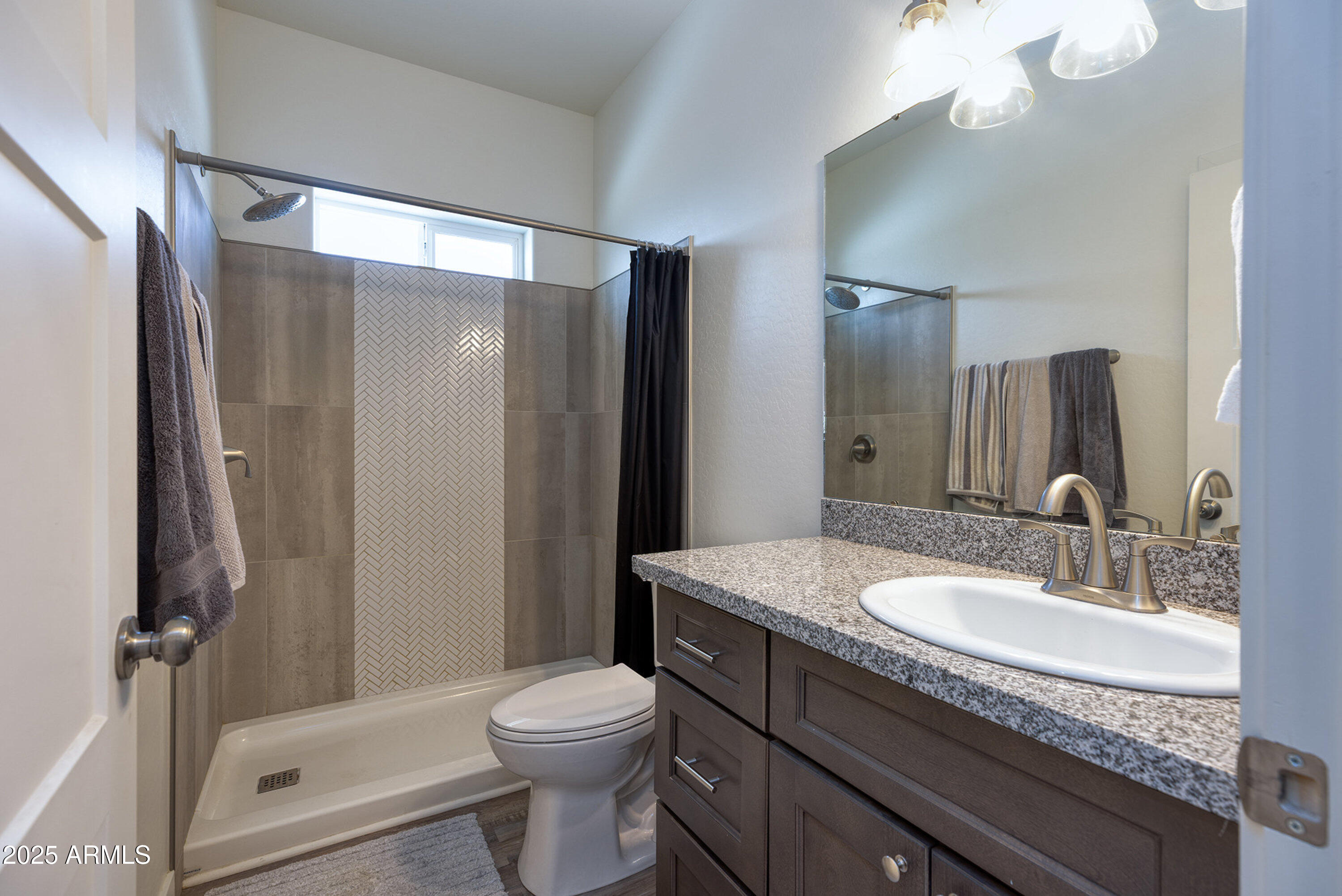 799 Cobble Lane Taylor, AZ 85939 - Photo 9 of 26 a bathroom with a granite countertop sink toilet and shower