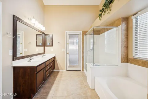 a spacious bathroom with a tub sink and mirror