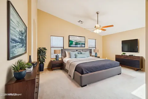 a spacious bedroom with a bed and a flat screen tv