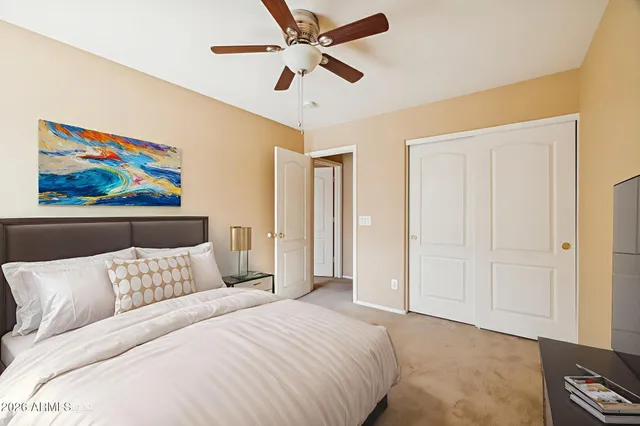 a bedroom with a bed and a painting on the wall