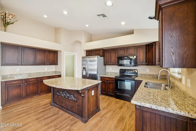 a large kitchen with stainless steel appliances granite countertop a counter a sink and a stove